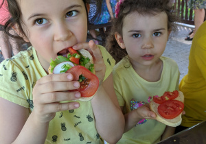 Zdjęcie przedstawia dziewczynki z grupy VI zjadające smaczne i zdrowe kanapki z warzywami przygotowane własnoręcznie